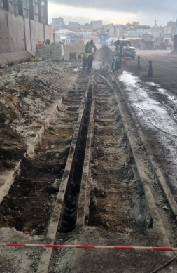 Rail track rehabilitation between industrial buildings.