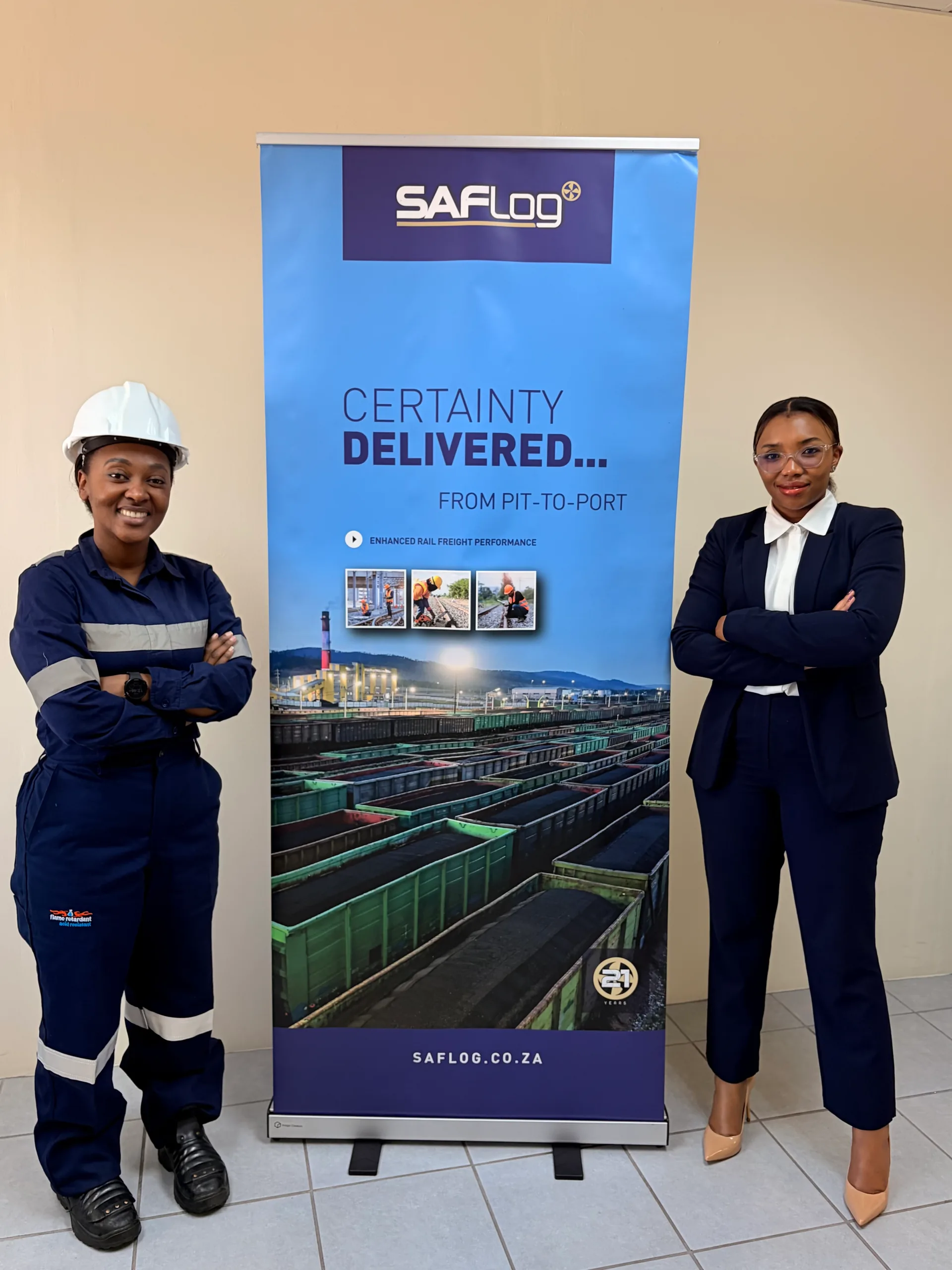 Two women standing on either side of a SAFLog banner.